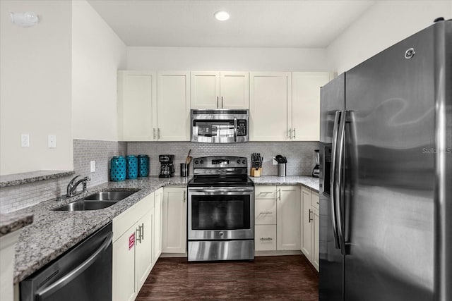 kitchen with white cabinets, stainless steel appliances, and light stone counters