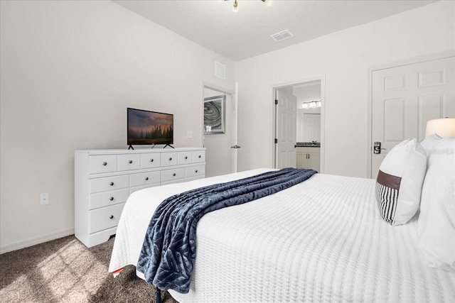 bedroom with ensuite bathroom and light carpet