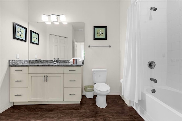 full bathroom with hardwood / wood-style floors, vanity, shower / tub combo, and toilet