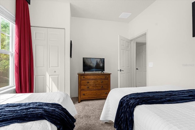 bedroom with light carpet and a closet