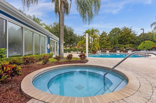 view of pool with a patio area and an in ground hot tub