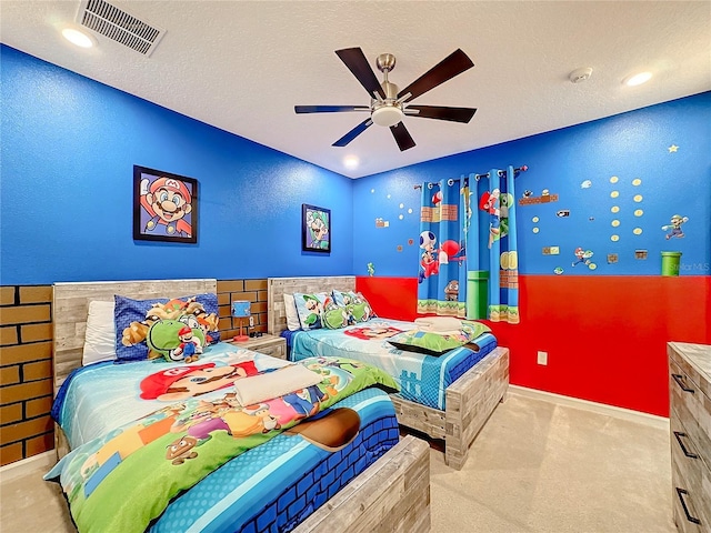 carpeted bedroom featuring ceiling fan and a textured ceiling