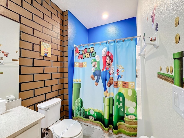 bathroom with a textured ceiling, vanity, toilet, and walk in shower