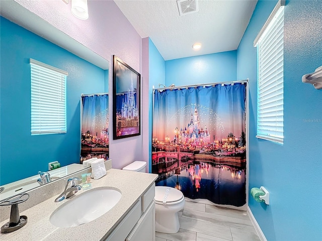 bathroom with tile patterned flooring, vanity, and toilet