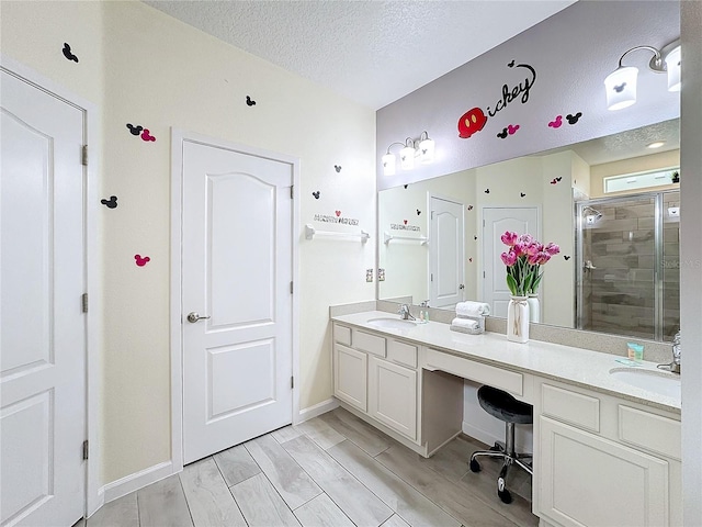 bathroom with vanity, a textured ceiling, hardwood / wood-style flooring, and an enclosed shower