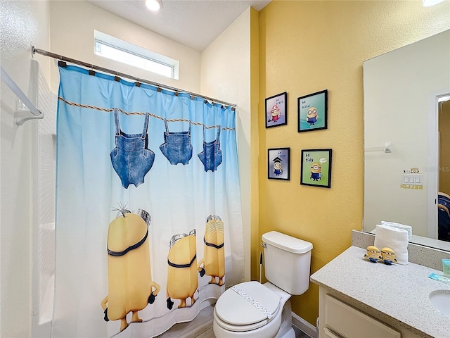 bathroom with a shower with shower curtain, vanity, and toilet