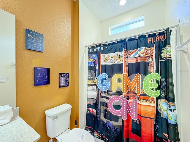 bathroom featuring a shower with curtain, vanity, a textured ceiling, and toilet