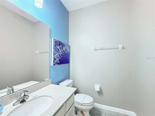 bathroom featuring tile patterned flooring, vanity, and toilet