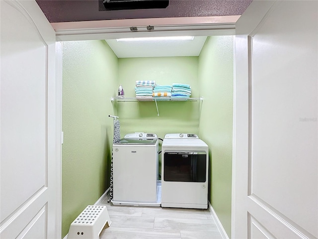 laundry area featuring washer and dryer and light hardwood / wood-style flooring