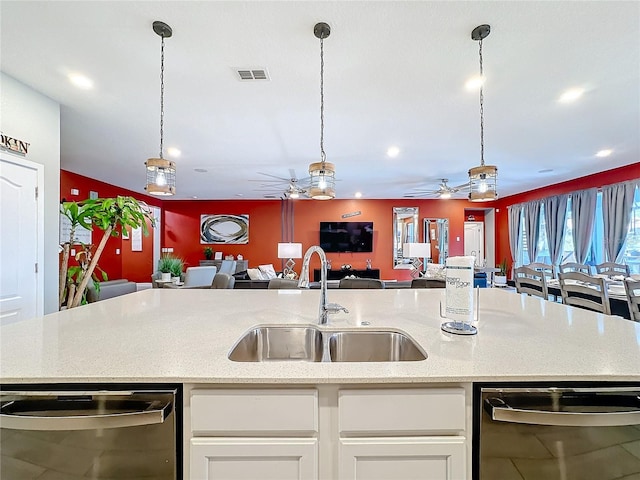 kitchen featuring white cabinetry, sink, stainless steel dishwasher, and decorative light fixtures