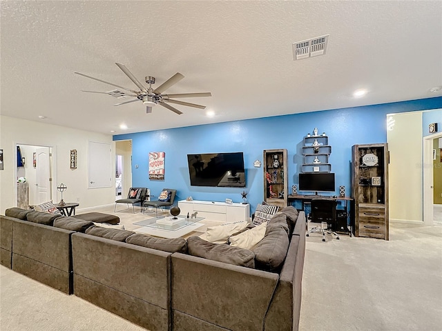 living room featuring light carpet, ceiling fan, and a textured ceiling