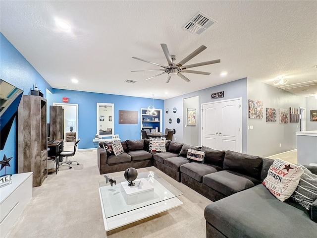 carpeted living room featuring a textured ceiling and ceiling fan