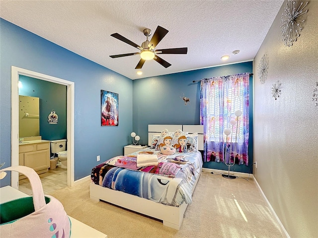 carpeted bedroom with ceiling fan, a textured ceiling, and connected bathroom