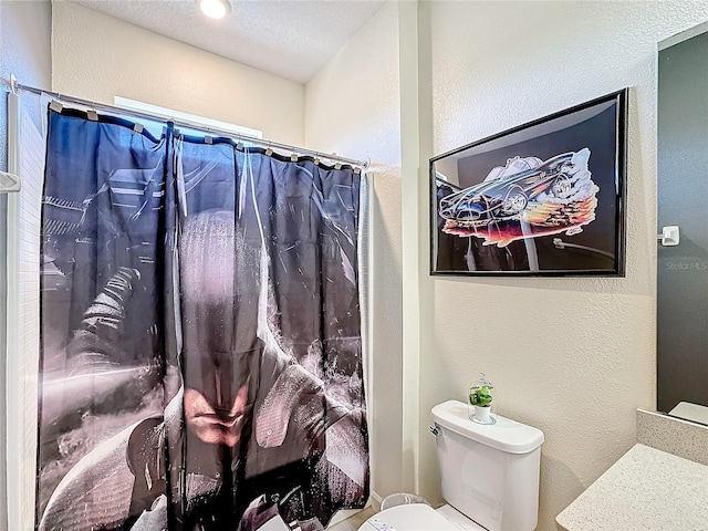 bathroom with a shower with shower curtain, vanity, toilet, and a textured ceiling