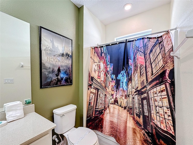 bathroom with a shower with shower curtain, vanity, toilet, and a textured ceiling