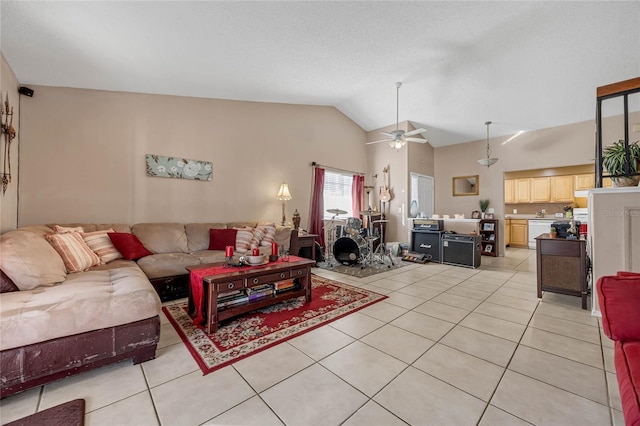 living room featuring ceiling fan, light tile patterned flooring, and lofted ceiling