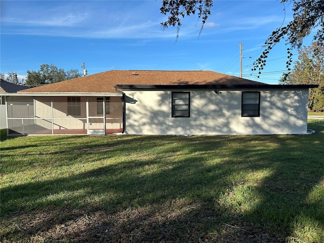 rear view of house with a sunroom and a yard