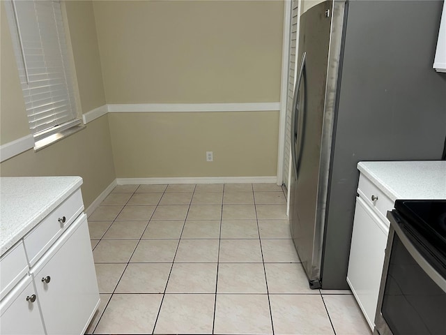 kitchen featuring white cabinets, light tile patterned flooring, and appliances with stainless steel finishes