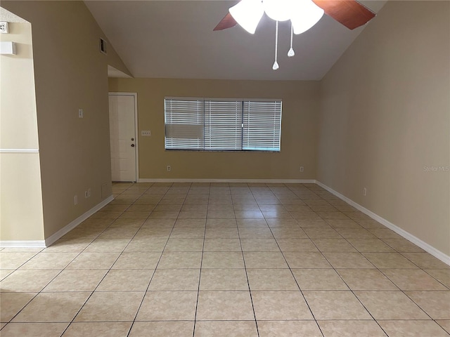 empty room with ceiling fan, lofted ceiling, and light tile patterned flooring