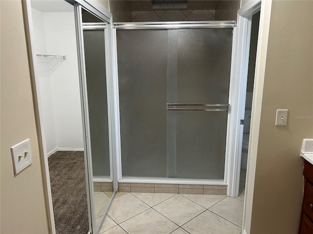 bathroom featuring tile patterned flooring, vanity, and a shower with shower door