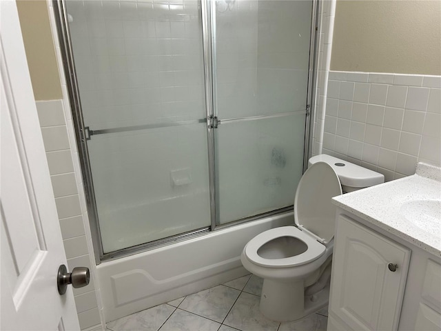 full bathroom featuring vanity, tile patterned flooring, toilet, enclosed tub / shower combo, and tile walls