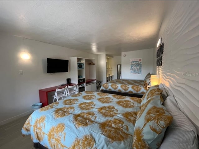 bedroom featuring hardwood / wood-style floors and a textured ceiling