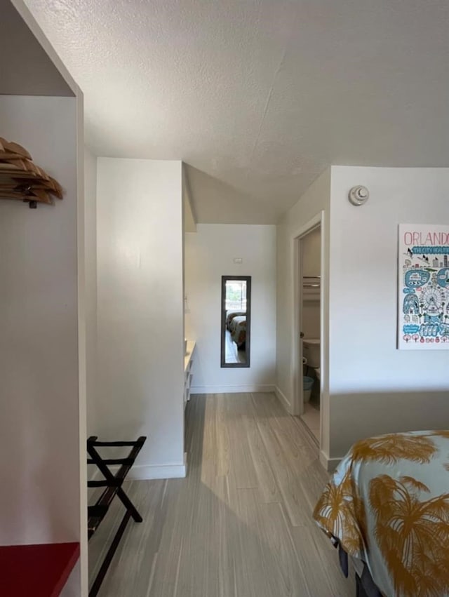 bedroom with a textured ceiling and light wood-type flooring