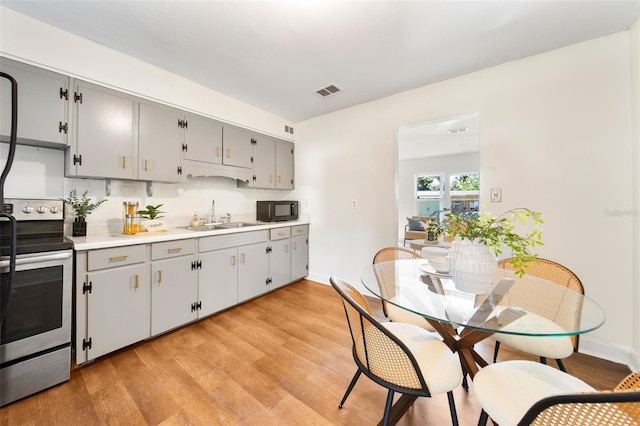 kitchen featuring sink, tasteful backsplash, gray cabinets, electric stove, and light wood-type flooring