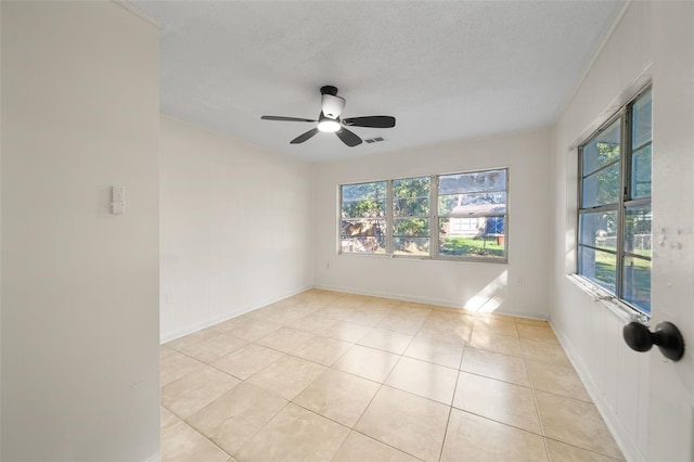 tiled empty room featuring ceiling fan and a textured ceiling