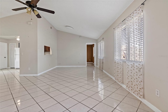 spare room with ceiling fan, light tile patterned flooring, and vaulted ceiling