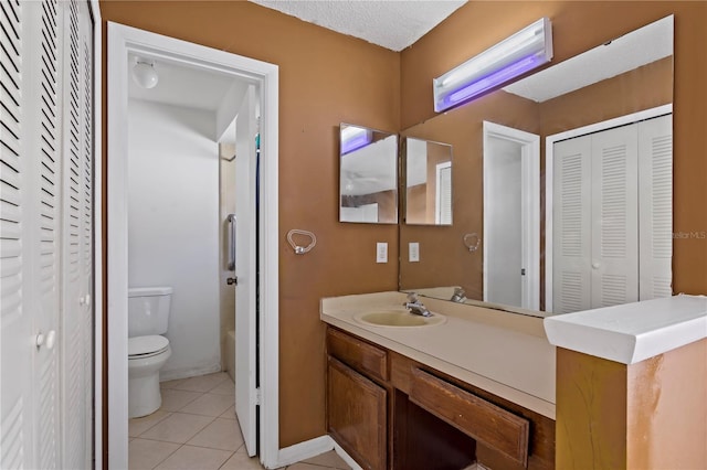 bathroom featuring tile patterned floors, vanity, a textured ceiling, and toilet