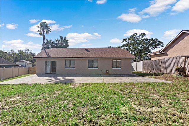 rear view of house with a yard and a patio