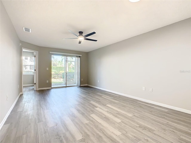 empty room with ceiling fan and light hardwood / wood-style flooring