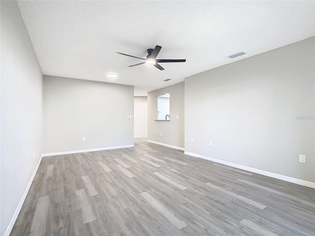 spare room featuring ceiling fan, light hardwood / wood-style floors, and a textured ceiling