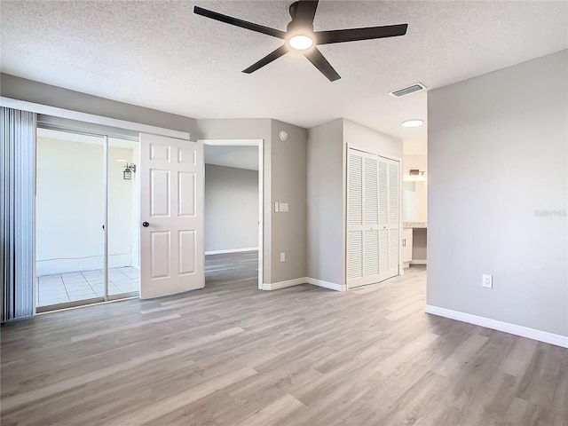 interior space featuring ceiling fan, a textured ceiling, and light wood-type flooring