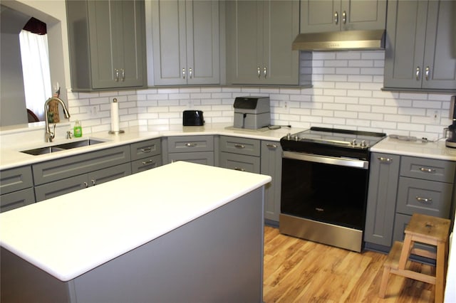 kitchen featuring gray cabinets, stainless steel range with electric cooktop, and exhaust hood