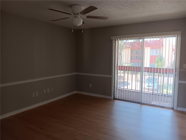 unfurnished room with a ceiling fan, a textured ceiling, baseboards, and wood finished floors