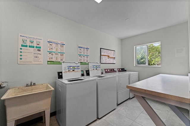 community laundry room featuring washer and dryer, a sink, and light tile patterned floors
