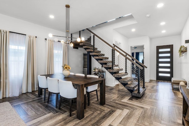 dining space featuring a notable chandelier, plenty of natural light, and dark parquet flooring