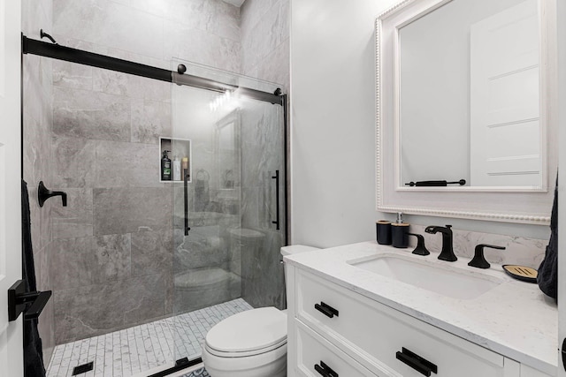 bathroom featuring vanity, toilet, and a shower with shower door