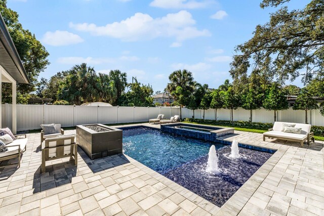 view of swimming pool with an in ground hot tub, an outdoor living space with a fire pit, and a patio area