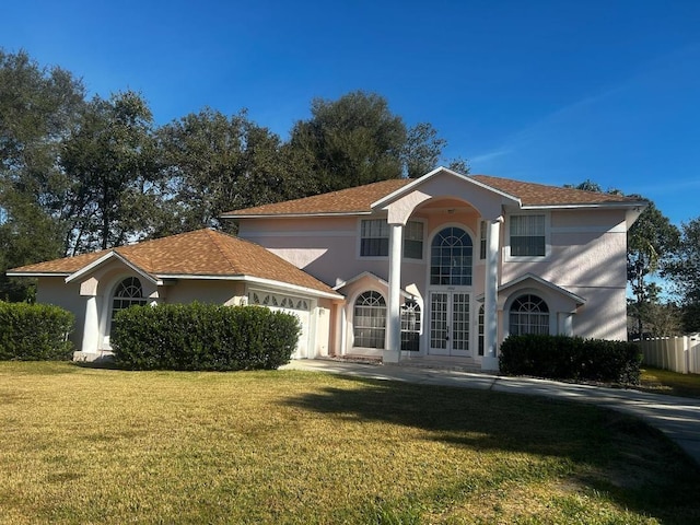 view of front facade featuring french doors, a garage, and a front lawn