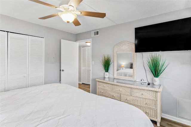 bedroom featuring hardwood / wood-style flooring, ceiling fan, and a textured ceiling