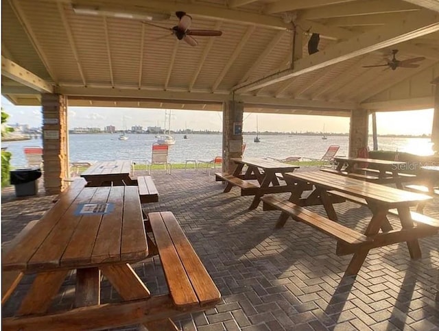 view of patio with a gazebo, a water view, and ceiling fan