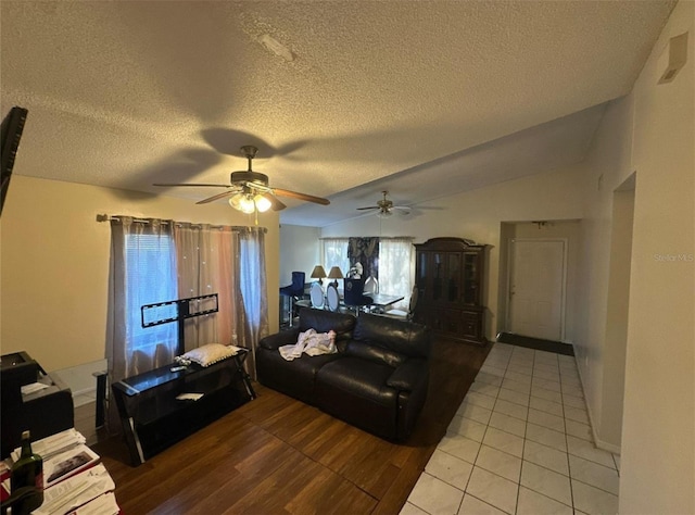 living room featuring light tile patterned floors, a textured ceiling, and ceiling fan