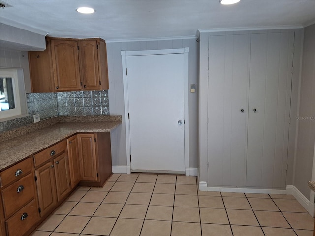 kitchen featuring light tile patterned floors, backsplash, and crown molding