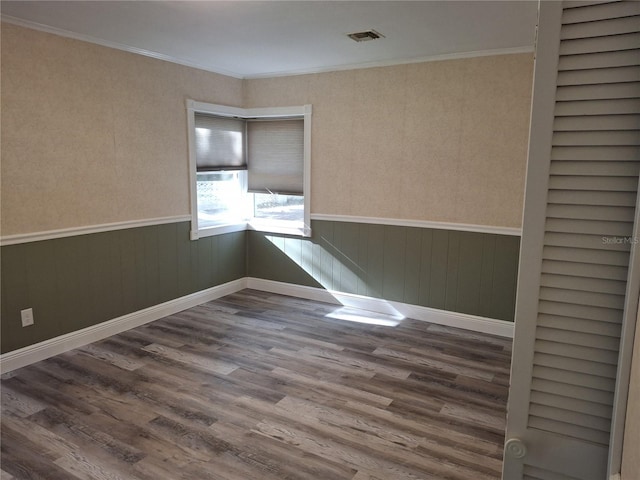 spare room with wood-type flooring and ornamental molding