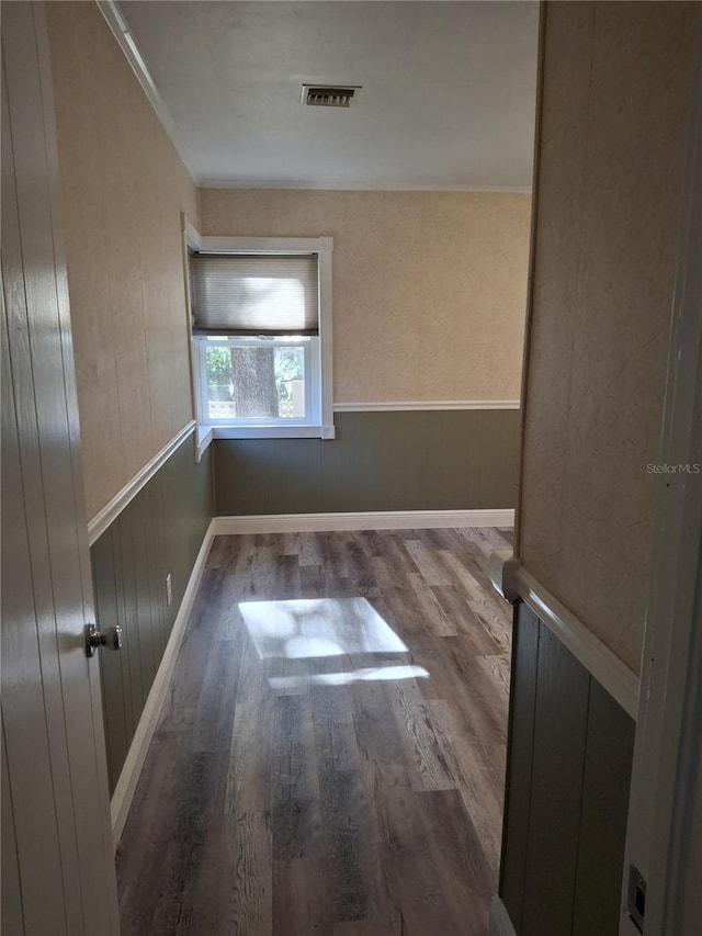 empty room featuring hardwood / wood-style flooring and wooden walls