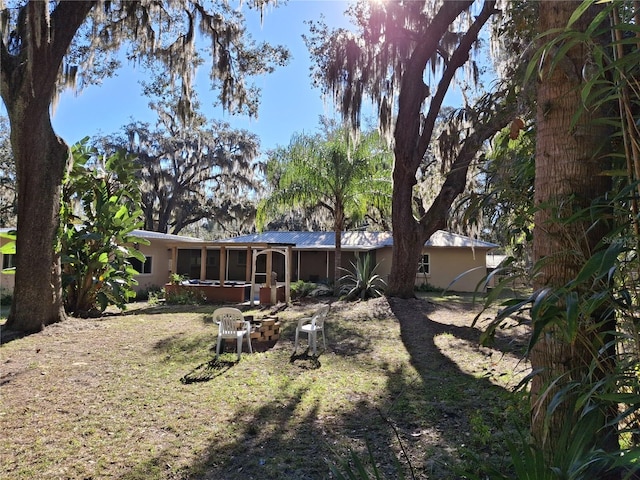 back of house featuring a lawn and a sunroom