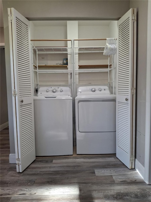 laundry room with washing machine and dryer and dark hardwood / wood-style flooring